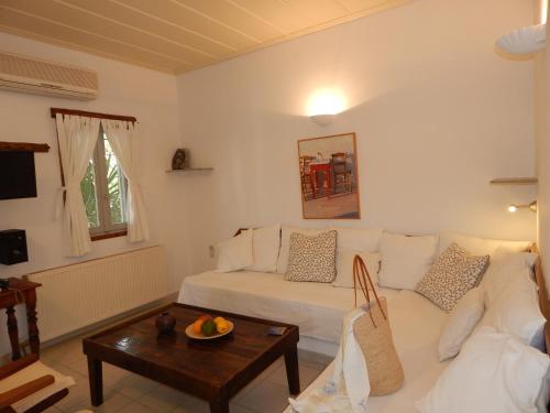 a living room with a white couch and a table at Paros Apartments in Parikia