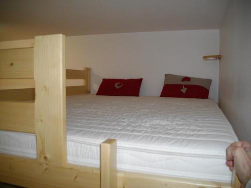 アルバールにあるLe clos des gentianesのベッドルーム1室(木製の二段ベッド1組、赤い枕付)