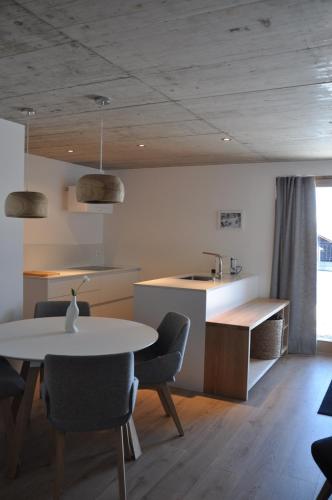 a kitchen with a table and chairs and a sink at Telemark Guesthouse in Nendaz