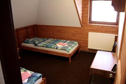 a small room with two beds and a window at Penzion u Hajneho Bedricha in Harrachov