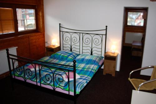 a bedroom with a bed and two tables with lamps at Penzion u Hajneho Bedricha in Harrachov