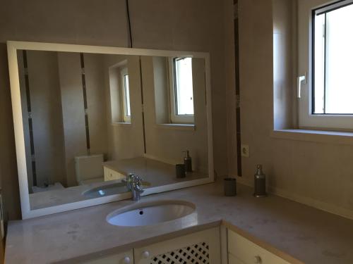 uma casa de banho com 2 lavatórios e um espelho grande em SolTroia Glamorous Apartament em Tróia