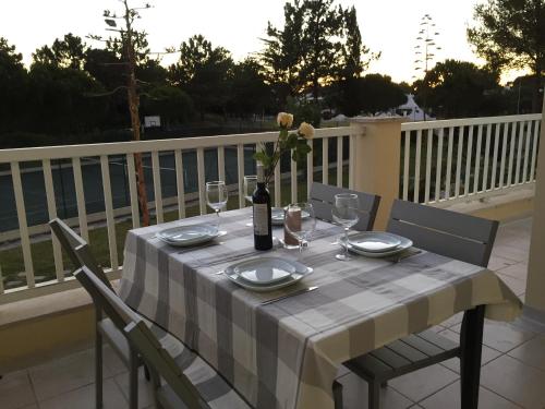 a table with a bottle of wine and glasses on a balcony at SolTroia Glamorous Apartament in Troia