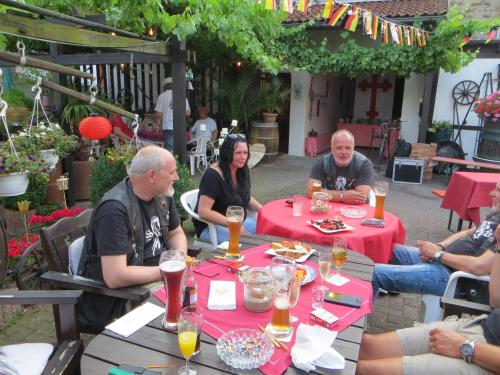 a group of people sitting at a table with red table cloth at Landgasthaus Zur Kupferkanne in Kobern-Gondorf