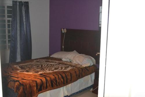 a bed in a room with a zebra print blanket at Honeybed Lodge in Lusaka