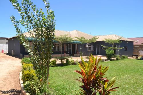 a house with a garden in front of it at Honeybed Lodge in Lusaka