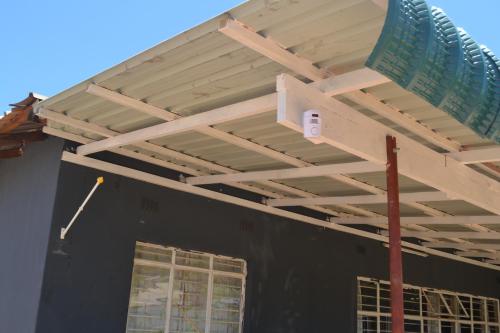 a wooden pergola on top of a black house at Honeybed Lodge in Lusaka