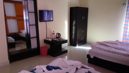 a bedroom with a bed and a desk and a mirror at Hotel Bay Wonders in Cox's Bazar