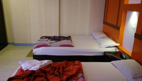 une chambre avec 3 lits dans une chambre d'hôtel dans l'établissement Hotel Bay Wonders, à Cox's Bazar