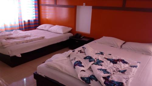 two beds sitting next to each other in a bedroom at Hotel Bay Wonders in Cox's Bazar