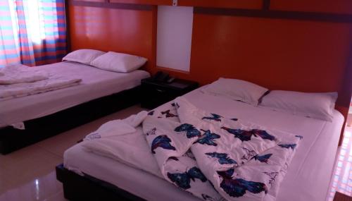two beds sitting next to each other in a bedroom at Hotel Bay Wonders in Cox's Bazar