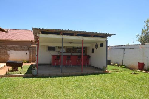 a small house with a patio with a bar at Honeybed Lodge in Lusaka