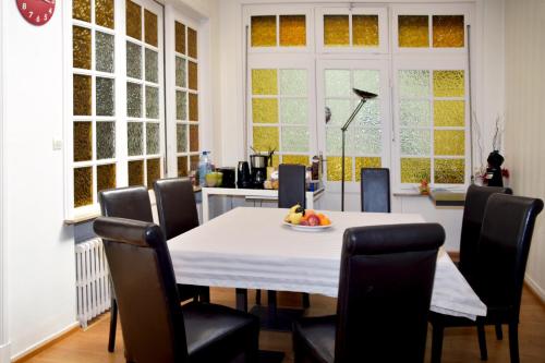 une salle à manger avec une table et des chaises blanches dans l'établissement Chambres d'hôtes L'Escale Malouine, à Dunkerque