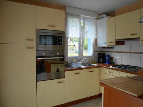 une cuisine avec un micro-ondes et une cuisinière four supérieur dans l'établissement LA MAISON EN PAIN D'EPICES, à Sainte-Marie-aux-Mines