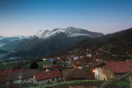 a view of a town with a snow covered mountain at La Xamoca Apartamentos Rurales in Campiellos