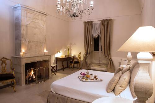 uma sala de estar com uma cama e uma lareira em Castello Camemi em Vizzini