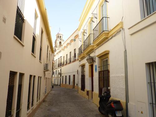 un callejón con una moto estacionada en un callejón entre edificios en Apartamentos Casa Rosaleda, en Jerez de la Frontera