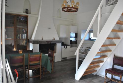 a kitchen and dining room with a table and stairs at Sandgårdsborg in Färjestaden