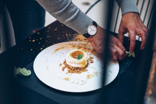 a person holding a plate with a dessert on it at Monastery Estate Venetian Harbor in Chania Town