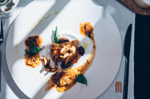 a white plate with food on a table at Monastery Estate Venetian Harbor in Chania Town