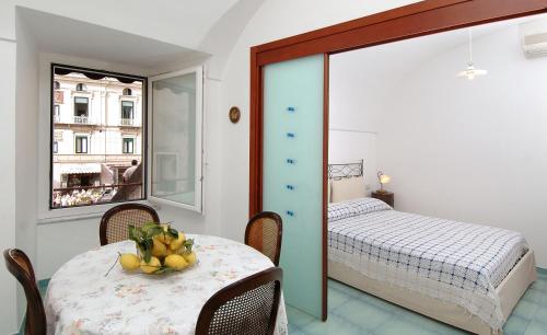 Habitación con mesa, cama y ventana en Quattro Passi, en Amalfi