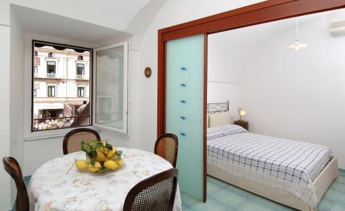 アマルフィにあるQuattro Passiのテーブルとベッド、窓が備わる客室です。