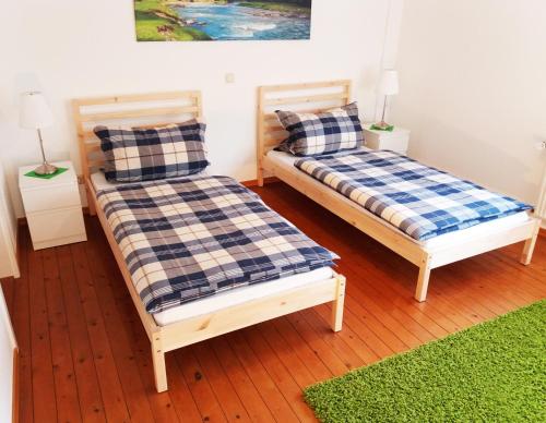 duas camas sentadas uma ao lado da outra num quarto em Gräfrath Gästehaus Neunkirchen-Seelscheid em Söntgerath