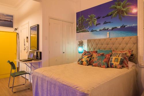 1 dormitorio con 1 cama y una pintura en la pared en Reformadíssimo na quadra praia de Copacabana Posto 6 na melhor localização do Rio - WiFi 500Mb, en Río de Janeiro