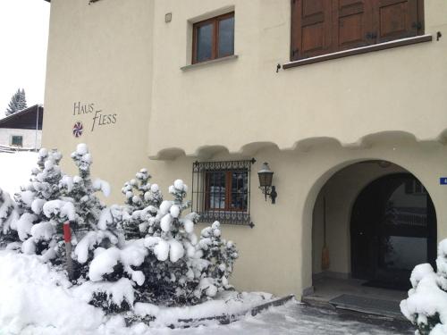 a building with a snow covered tree in front of it at Haus Fless 7 in Klosters Dorf