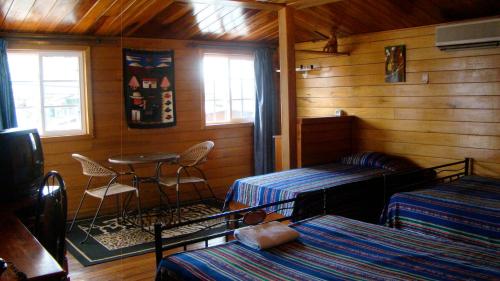 a room with two beds and a table in a cabin at Hotel Laguna in Bocas Town