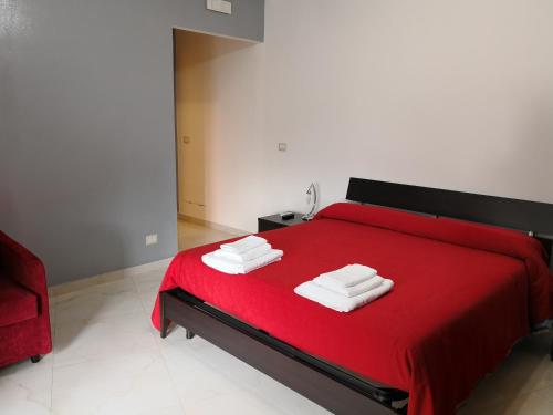 a bedroom with a red bed with towels on it at B&B LA CASA DI GIORGIA DI PELLICANO' FRANCESCA in Reggio di Calabria