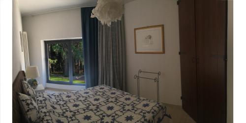 een slaapkamer met een bed en een raam bij Villa Giovannozzi - Swimming Pool & Tennis Court in Ascoli Piceno