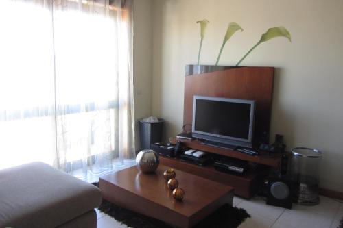 a living room with a television on a table at Apartamento Superior Helena's Porto Corner in Vila Nova de Gaia