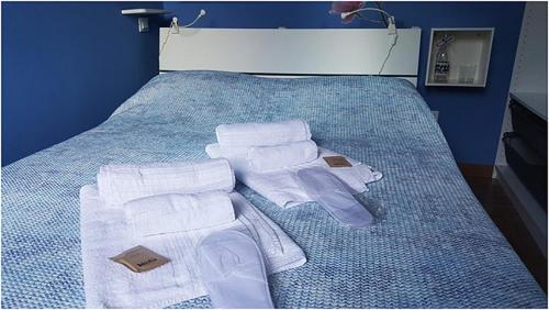Una cama con toallas y toallas plegadas. en Piccola Suite Blu en Padova