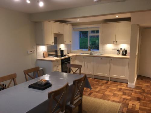 a kitchen with a table and chairs in a room at Garden Cottage in Carsluith