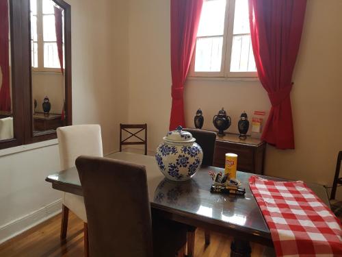ein Esszimmer mit einem Tisch und einer Vase darauf in der Unterkunft Casa Mackenna in Valparaíso