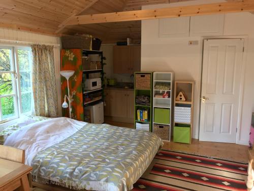 a bedroom with a bed and a kitchen at Crabapple Cottage B&B in Lewes