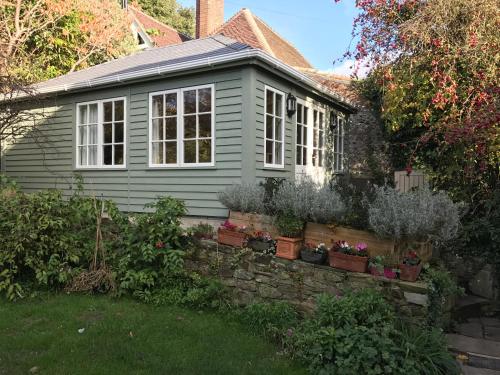 a small house with potted plants in the yard at Crabapple Cottage B&B in Lewes
