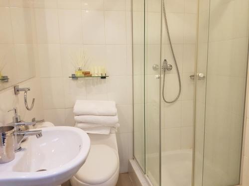 een badkamer met een douche, een toilet en een wastafel bij Casa Mackenna in Valparaíso