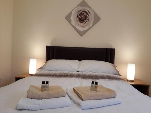 um quarto com uma cama com duas toalhas em Crystal Apartments em Airdrie