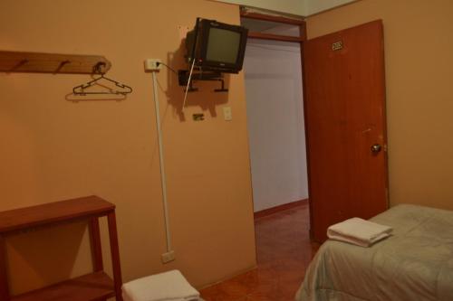 een kamer met een bed en een televisie aan de muur bij hotel MISKY PUÑUY - Valle del Sondondo in Andamarca