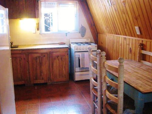 eine Küche mit Tisch und Herd und Fenster in der Unterkunft Casa Alpina Frente al Mar - Aguas Verdes in Aguas Verdes