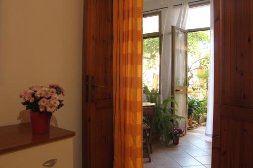 a hallway with an open door with a vase of flowers at Fiori e Limoni in Quartucciu