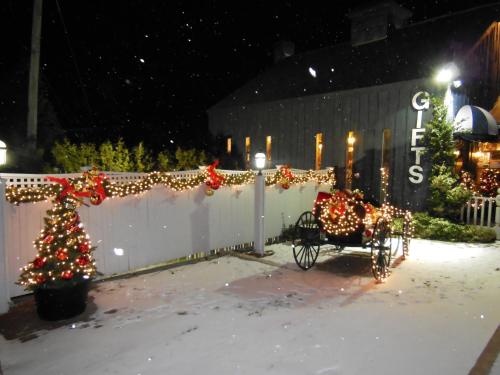 a christmas yard with a sleigh and a christmas tree at Greenbrier Inn Killington in Killington