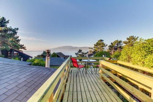 a wooden deck with a table and chairs on it at AmbienteMar Cabañas in Papudo