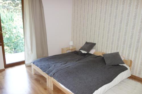 a bedroom with a bed with a gray blanket at Bujaków, apartamenty Zdrojowa 58a in Bujaków