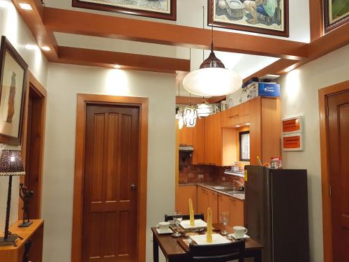 a kitchen with wooden cabinets and a black refrigerator at Stay Amare Villa Maria 2 in Bacolod