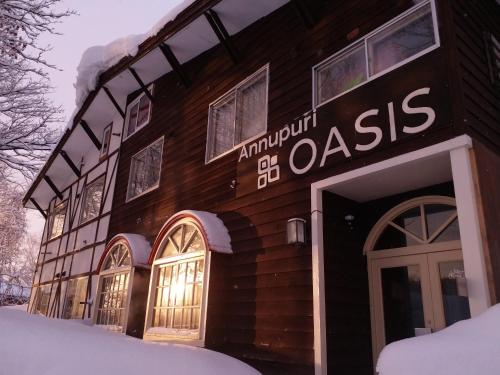 a building with a sign on it in the snow at Annupuri Oasis Lodge in Kutchan