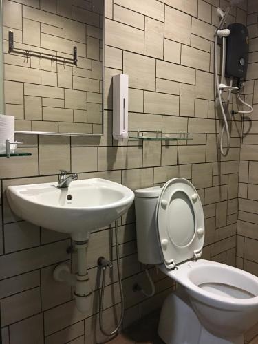 a bathroom with a sink and a toilet and a phone at Signature Hotel @ Bangsar South in Kuala Lumpur