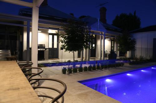 a swimming pool in front of a house at night at Hollidge House 5 Star Luxury Apartments in Adelaide
